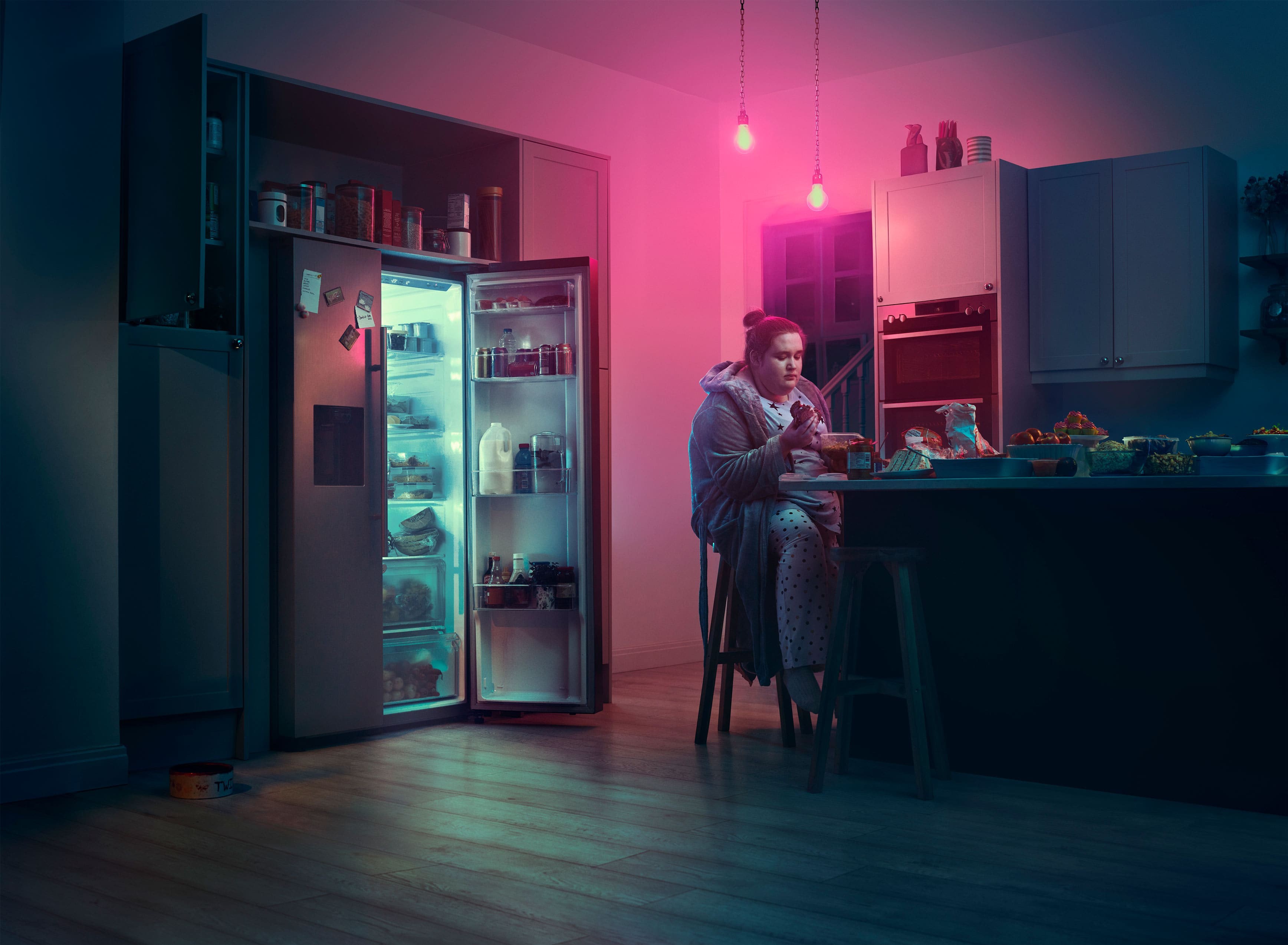 Girl sitting at kitchen counter and eating. Actor portrayal.